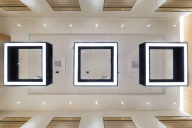 Halojen lambalı asma tavan ve boş bir oda ya da evde alçıpan inşaatı. Gergin tavan beyaz ve karmaşık şekil.