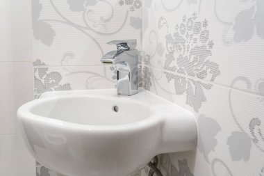 Pahalı banyoda musluk musluğu ve musluğu olan beyaz seramik lavabo.