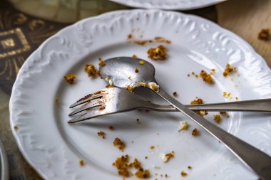 Kahvaltıdan sonra masada çatal ve kaşıkla kirli tabağı boşalt.