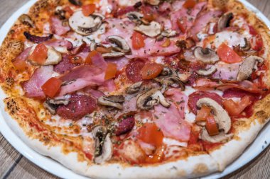 Lezzetli klasik İtalyan pizzası jambon, domates, mantar ve peynirli. 