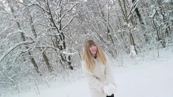 สวยย นใจสาวผ วขาวใบหน าสวยในเส อขนส ขาวมองไปท งโยนห มะในป าฤด หนาว — วีดีโอสต็อก