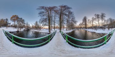 full winter seamless spherical hdri panorama 360 degrees  angle view on wooden bridge over small river in snowy forest in equirectangular projection, VR AR content.  clipart