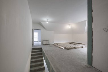 Tamiri ve mobilyası olmayan beton merdivenli boş beyaz oda.