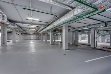 Boş yeraltı otoparkı. Sütunları ve yol işaretleri var.