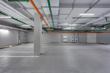 Boş yeraltı otoparkı. Sütunları ve yol işaretleri var.