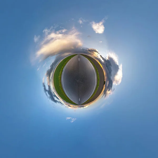 tiny planet in blue sky with sun and beautiful clouds. Transformation of spherical panorama 360 degrees. Spherical abstract aerial view. Curvature of space.