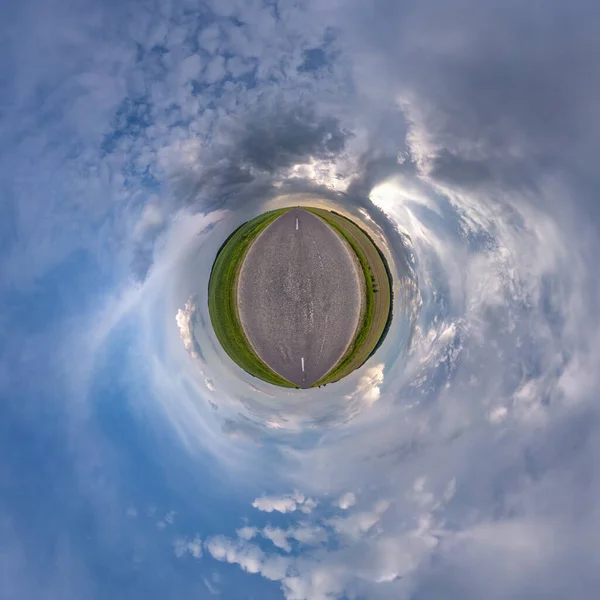 tiny planet in blue sky with sun and beautiful clouds. Transformation of spherical panorama 360 degrees. Spherical abstract aerial view. Curvature of space.