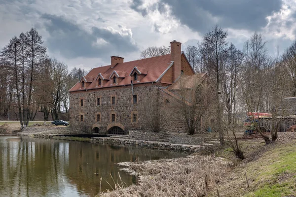 the building of the restored old stone mill in early spring near lake