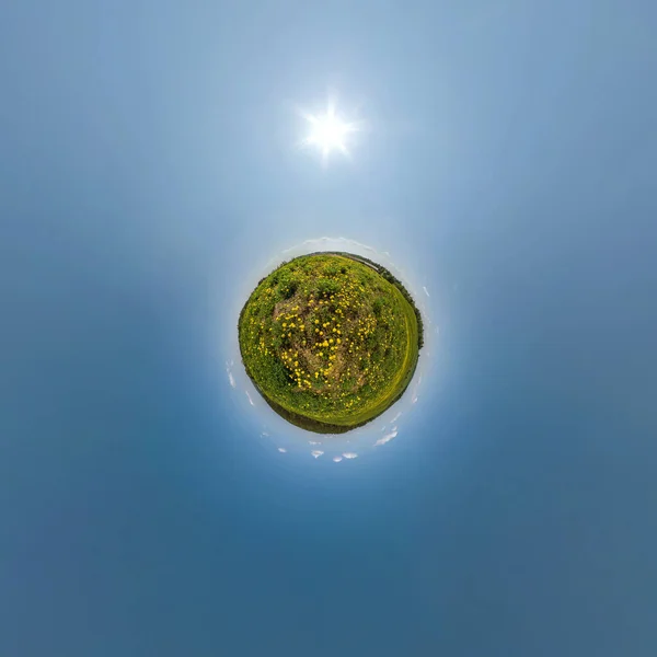 tiny planet on dandelion field in blue sky with beautiful clouds. Transformation of spherical panorama 360 degrees. Spherical abstract aerial view. Curvature of space.
