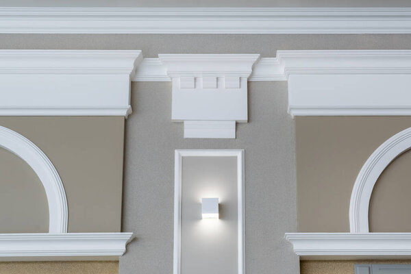 Detail of corner ceiling with intricate crown molding on column with spot light