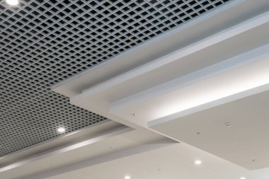 Halojen benekli lambalar ve boş oda veya evde alçıpan inşaatı olan asılmış ve ızgara tavanı. Gergin tavan beyaz ve karmaşık şekil.