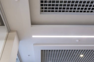Halojen benekli lambalar ve boş oda veya evde alçıpan inşaatı olan asılmış ve ızgara tavanı. Gergin tavan beyaz ve karmaşık şekil.