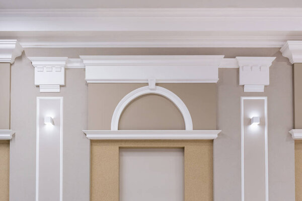Detail of corner ceiling with intricate crown molding on column with spot light