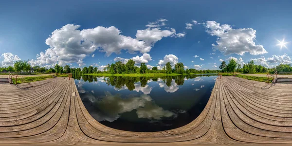 Tam kusursuz küresel hdri panorama 360 derecelik açıyla sabahları ya da gün batımında gölün ahşap iskele ya da nehir manzarası güzel bulutlar ve eş dikdörtgen projeksiyondaki muhteşem yansıma, VR içeriği
