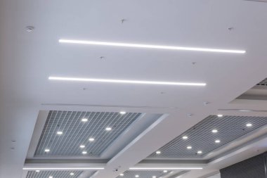 Halojen benekli lambalar ve boş oda veya evde alçıpan inşaatı olan asılmış ve ızgara tavanı. Gergin tavan beyaz ve karmaşık şekil.