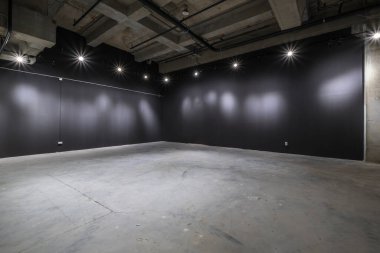 Büyük beton odanın içi depo ya da spot ışıkları olan bir hangar gibi boş.