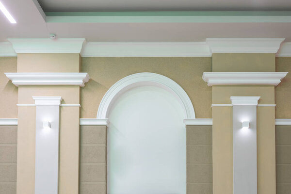 Detail of corner ceiling with intricate crown molding on column with spot light	