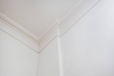 Tavan ve duvarların köşesinde karmaşık taç kalıpları var. İç yapı ve yenileme konsepti.