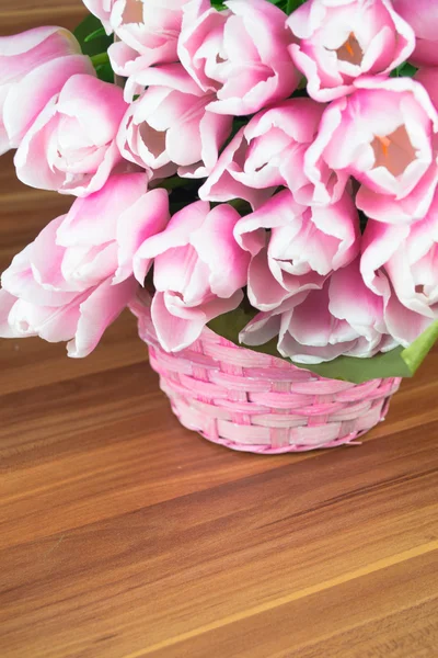 Pink tulips in a basket over shabby wooden background — Stock Photo, Image