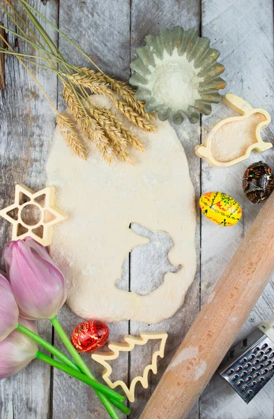 Пасхальная выпечка. Сырое тесто и форма для праздничного печенья на деревянном столе . — стоковое фото
