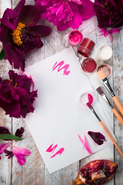 Spazio di lavoro. Acquerello, pennello e peonie rosa isolati su sfondo bianco. Vista dall'alto. Posa piatta, vista dall'alto — Foto Stock