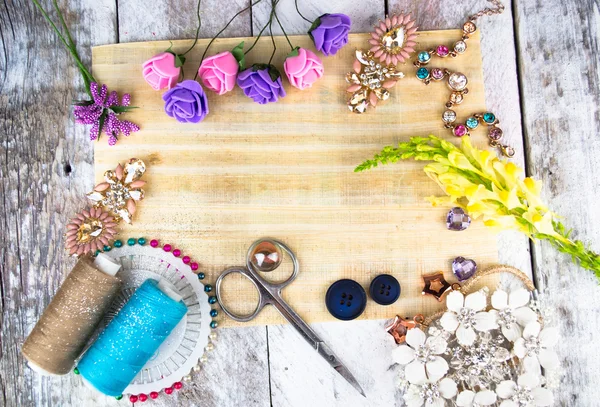 Plastic berries, flowers, beads and instruments on white wood background — Stock Photo, Image