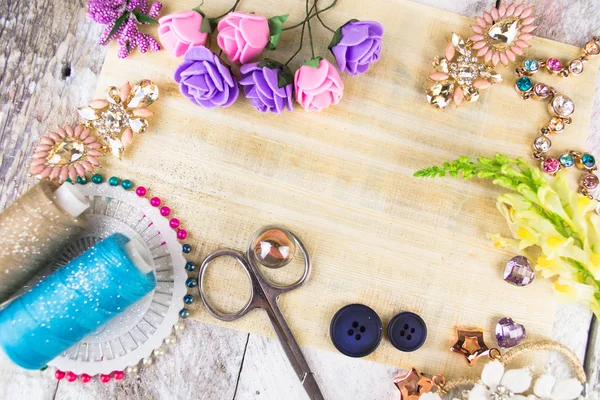 Plastic berries, flowers, beads and instruments on white wood background — Stock Photo, Image