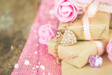 Hediye kutusu dekor. Parşömen kağıtları, altın kalp hassas taze pembe çiçeklerle sarılmış