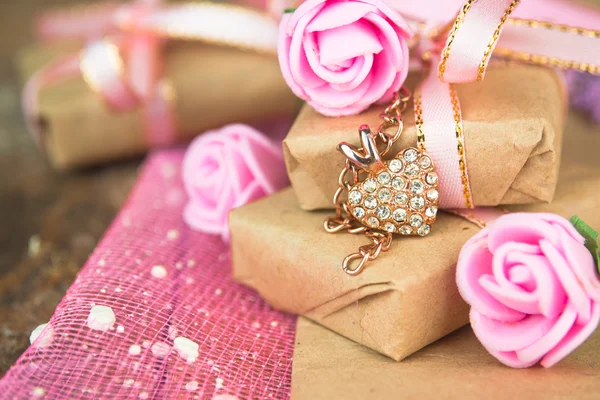 Hediye kutusu dekor. Parşömen kağıtları, altın kalp hassas taze pembe çiçeklerle sarılmış — Stok fotoğraf
