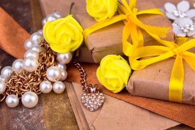 Doğal ahşap masa üstten görünüm kağıda sarılı sarı hediye kutusu