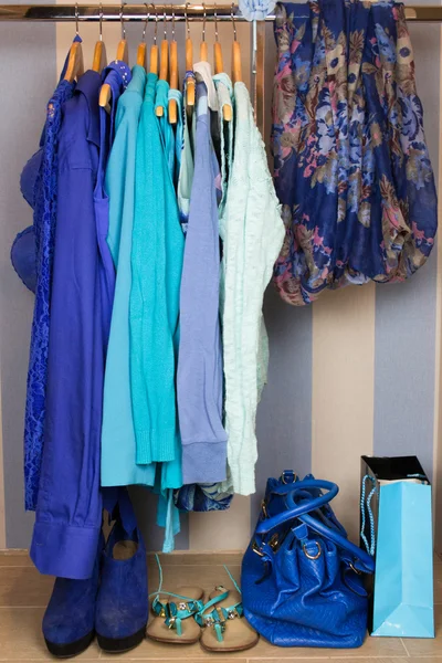 Dressing closet with blue clothes arranged on hangers — Stock Photo, Image