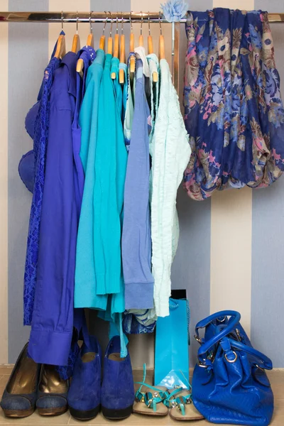 Omhoog het kleden van kast met blauwe kleren gerangschikt op hangers — Stockfoto