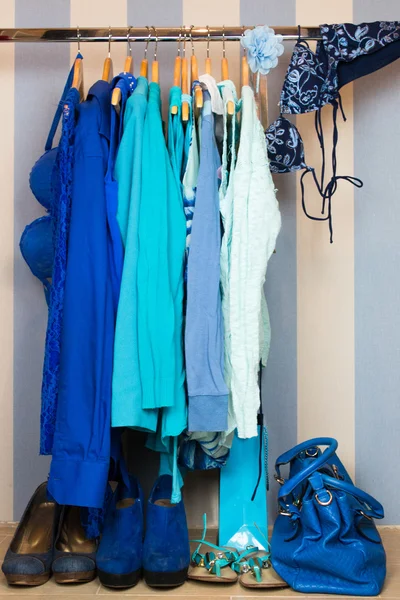 Omhoog het kleden van kast met blauwe kleren gerangschikt op hangers — Stockfoto