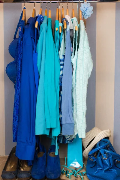 Omhoog het kleden van kast met blauwe kleren gerangschikt op hangers — Stockfoto