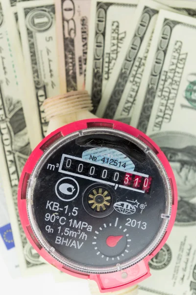 A water meter on a heap of US 100 dollar notes — Stock Photo, Image