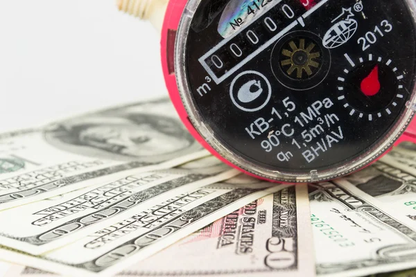 A water meter on a heap of US 100 dollar notes — Stock Photo, Image