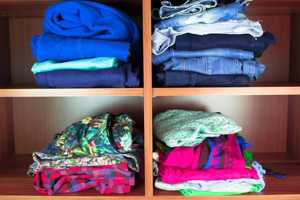 Vêtements soigneusement pliés sur des étagères — Photo