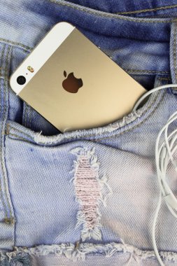 Altın elma iphone 5'ler bir mavi kot cebinde
