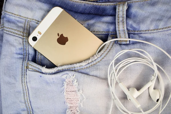 Apple Gold iPhone 5s in a blue denim pocket — Stock Photo, Image