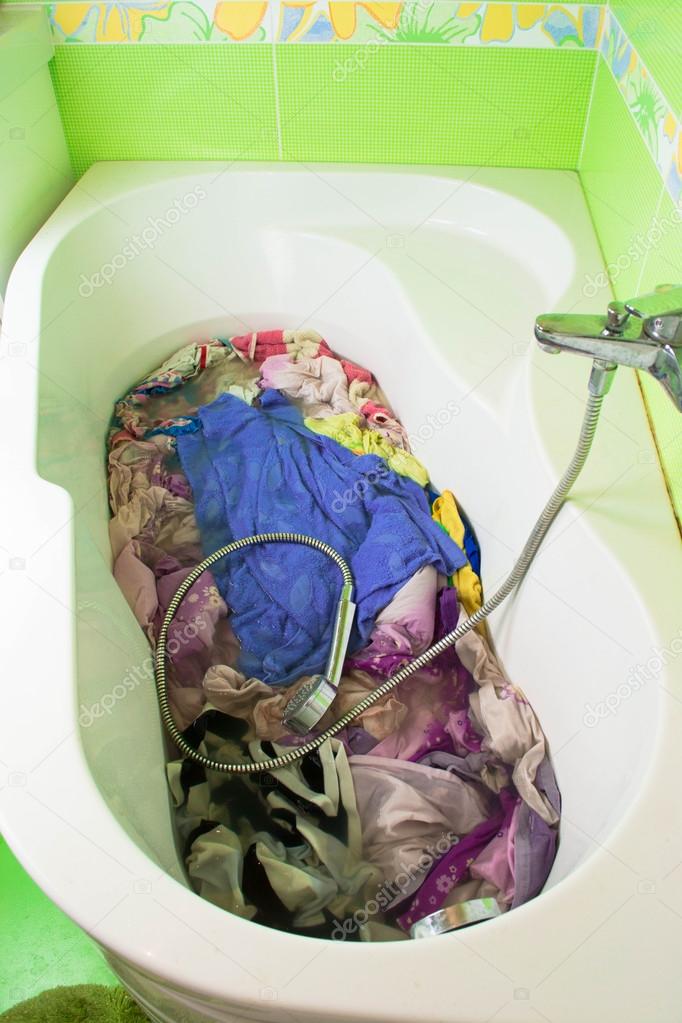 Dirty clothes soak in tub with detergent before washing