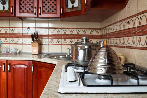 Интерьер деревянной кухни. Сковорода и чайник на плите — стоковое фото