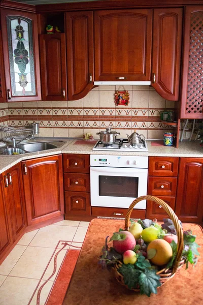 Интерьер деревянной кухни. Декоративная корзина с фруктами на столе — стоковое фото