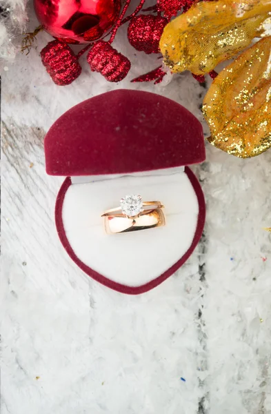 Wedding ring among Christmas decorations on wood background. — Stock Photo, Image