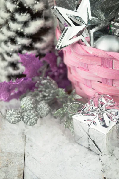 Roze kerst mand met zilveren speelgoed op een witte houten achtergrond — Stockfoto