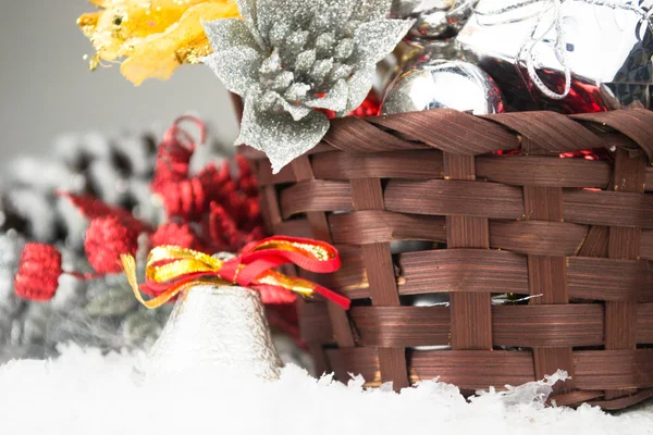 布朗的圣诞节篮子与白色的木制背景上的银色和金色玩具 — 图库照片