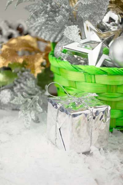 Panier de Noël vert avec des jouets en argent sur un fond en bois blanc — Photo