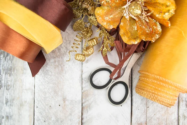 Golden wrapping paper and bow for Christmas present decoration on wood — Stock Photo, Image