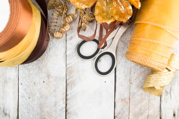 Carta da regalo dorata e fiocco per addobbi natalizi su legno — Foto Stock