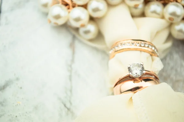 Anéis de casamento dourados no fundo de madeira branca — Fotografia de Stock