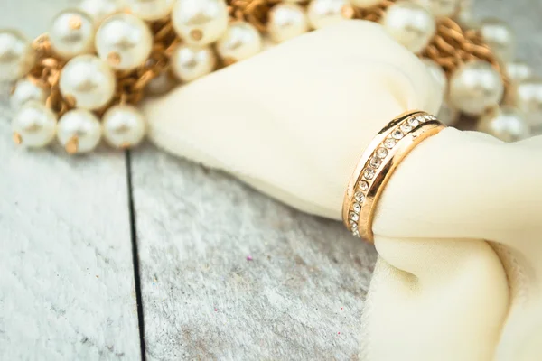 白色木背景上的金色结婚戒指。 图库图片